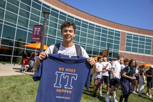 Student holding a convocation shirt