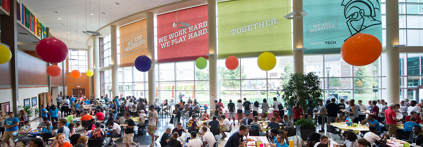Students socializing and eating together in the Andorfer Dining Hall during Orientation and Welcome Week